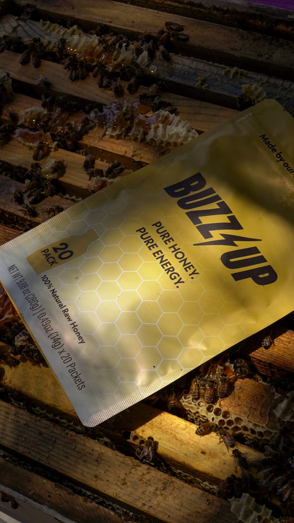 Buzz Up bag resting on a honeycomb frame with bees